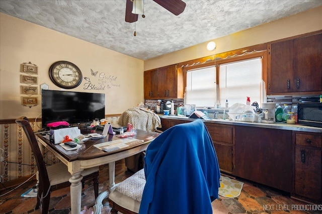 dining space with ceiling fan and a textured ceiling