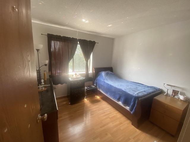 bedroom featuring hardwood / wood-style flooring and a textured ceiling