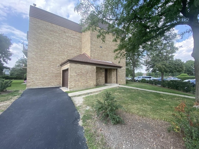 view of property exterior featuring a garage and a lawn