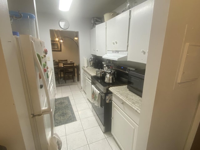 kitchen featuring black range with electric cooktop, white fridge, white cabinets, and light tile patterned flooring