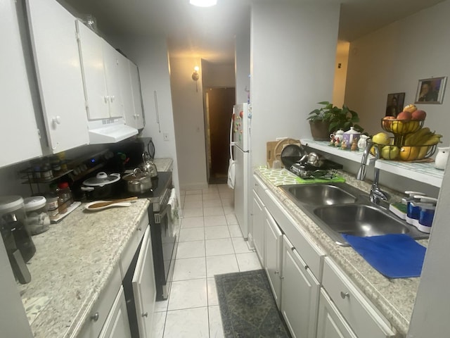 kitchen with white cabinetry, white refrigerator, light tile patterned flooring, and electric range oven