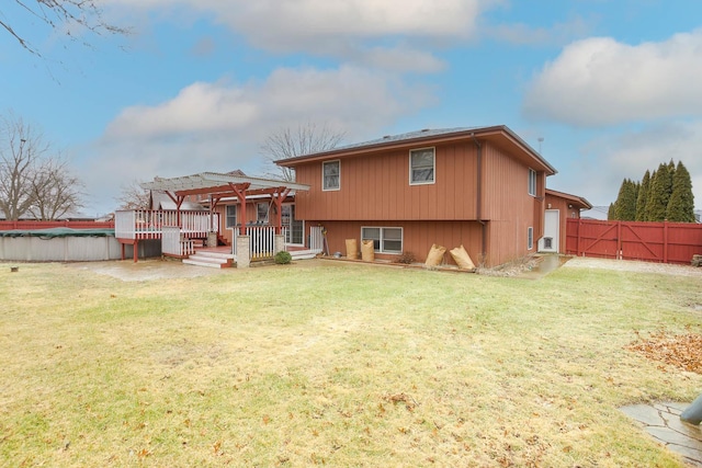 rear view of house with a pool side deck, a pergola, and a lawn