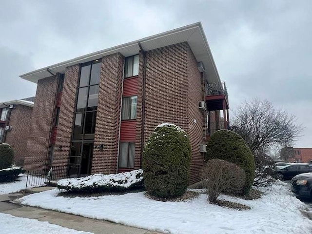 view of snow covered exterior featuring brick siding