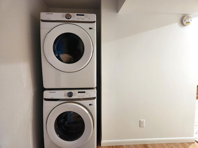 washroom featuring stacked washer and dryer and light wood-type flooring