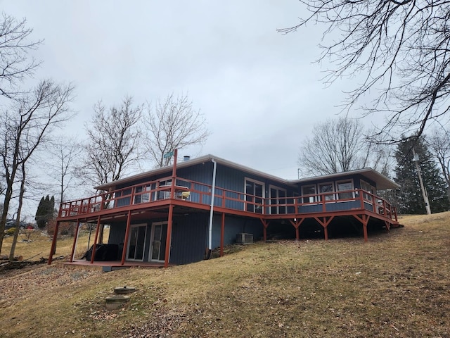 back of house featuring central AC unit, a lawn, and a deck