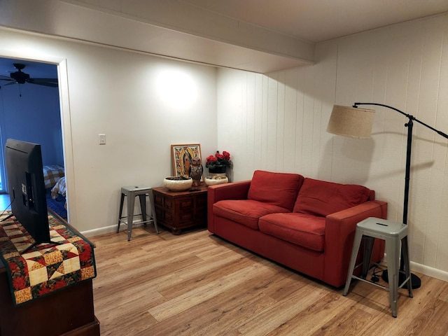 living room featuring beam ceiling, wood-type flooring, and ceiling fan