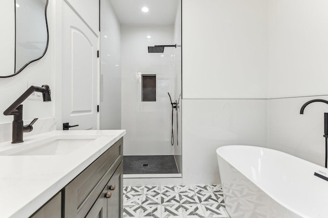 full bathroom with a walk in shower, a soaking tub, and vanity