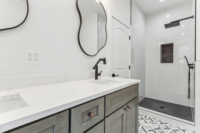 bathroom featuring double vanity, a walk in shower, and a sink