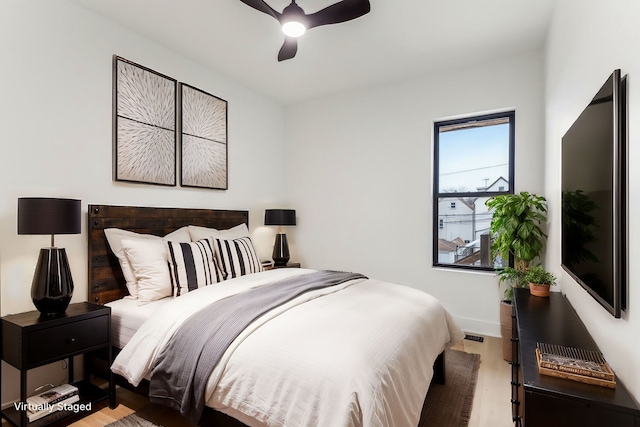 bedroom with ceiling fan, baseboards, and wood finished floors