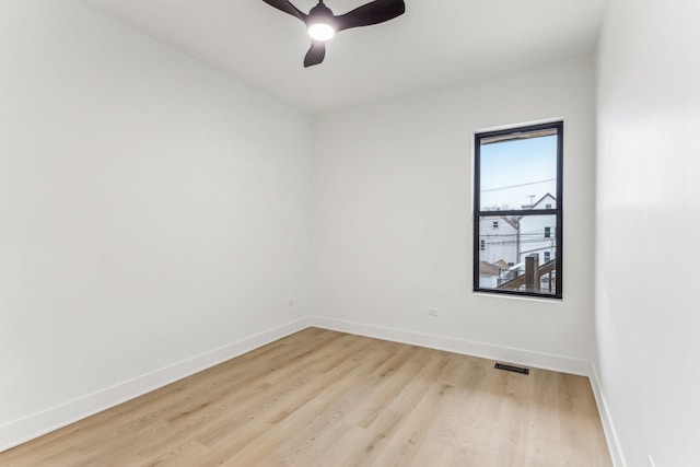 unfurnished room featuring baseboards, ceiling fan, visible vents, and light wood finished floors