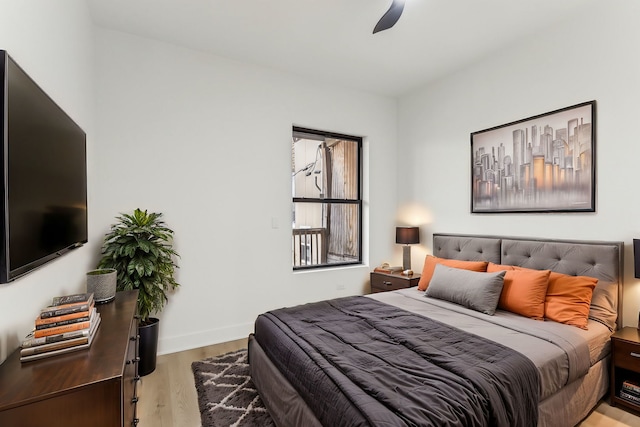 bedroom featuring baseboards, ceiling fan, and light wood finished floors