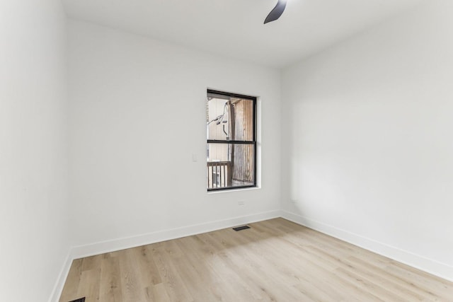 spare room featuring baseboards, visible vents, and light wood-style floors