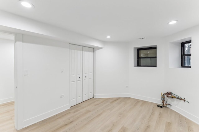 below grade area with light wood-style floors, baseboards, and recessed lighting