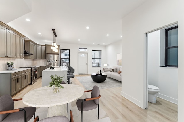 dining space with light wood-type flooring, baseboards, and recessed lighting