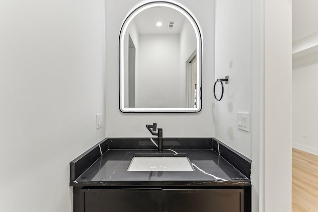 bathroom featuring visible vents, vanity, and wood finished floors