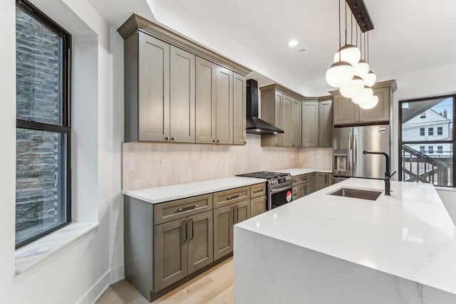 kitchen featuring wall chimney range hood, tasteful backsplash, appliances with stainless steel finishes, and light stone counters