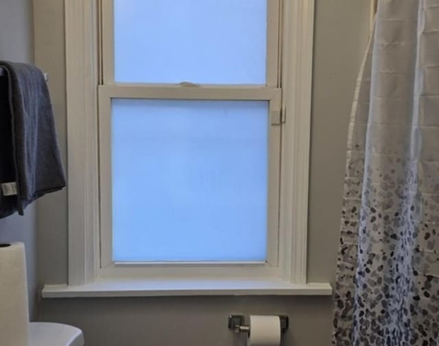 bathroom view of a shower with curtain and toilet