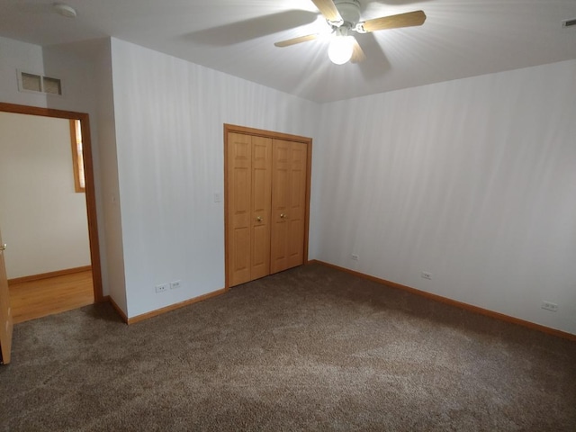 unfurnished bedroom featuring dark carpet, a closet, and ceiling fan