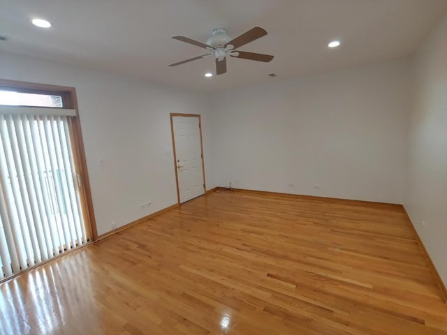 spare room featuring ceiling fan, a healthy amount of sunlight, and light hardwood / wood-style flooring