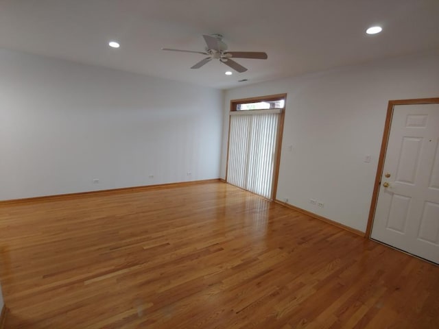 empty room with ceiling fan and light hardwood / wood-style flooring