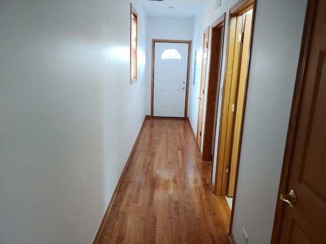 corridor with light hardwood / wood-style floors