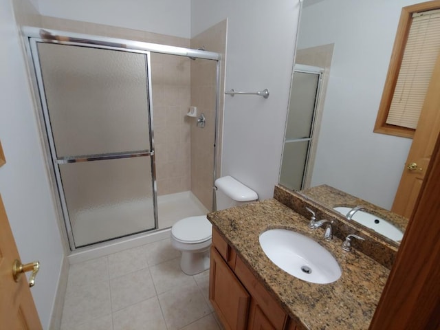 bathroom with toilet, vanity, tile patterned floors, and walk in shower