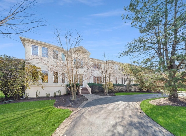 view of front of home featuring aphalt driveway and a front lawn