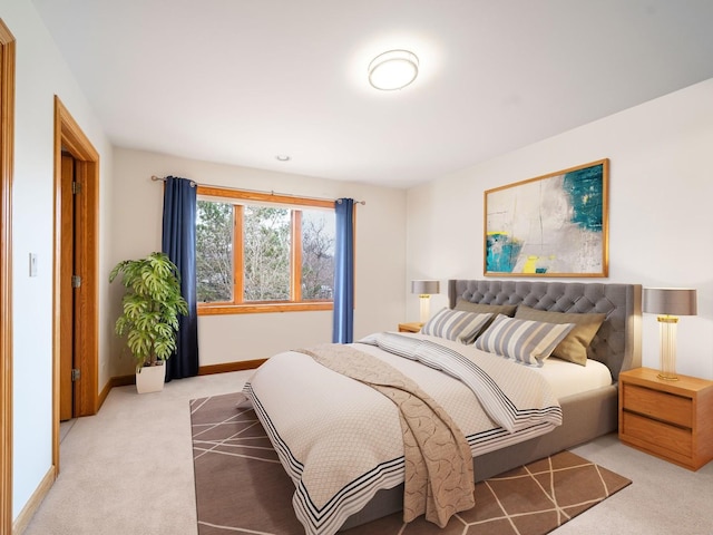 bedroom with light colored carpet and baseboards