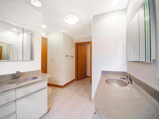 full bath with two vanities, a sink, tile patterned flooring, and baseboards