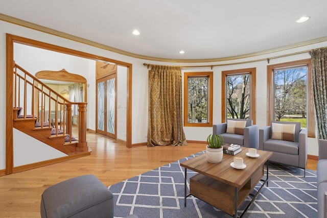 living area with recessed lighting, wood finished floors, baseboards, stairs, and ornamental molding