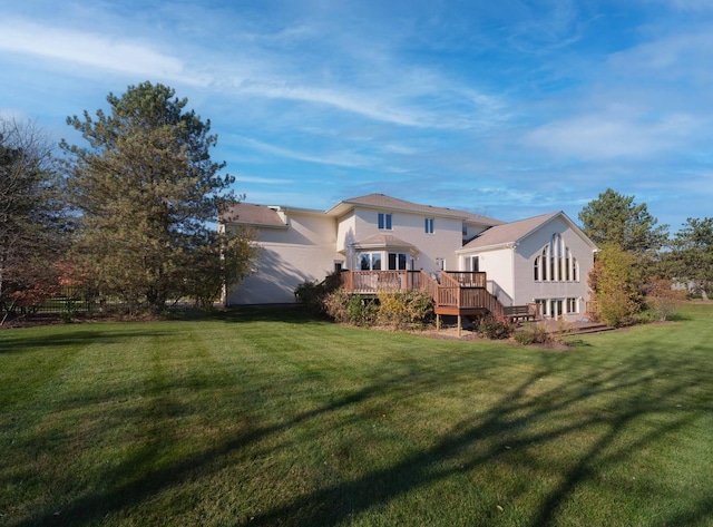 rear view of house featuring a yard and a wooden deck