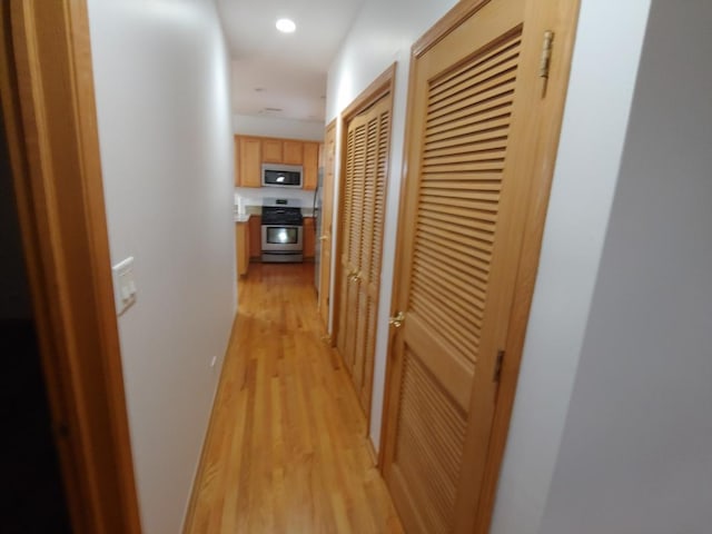 corridor with light hardwood / wood-style floors