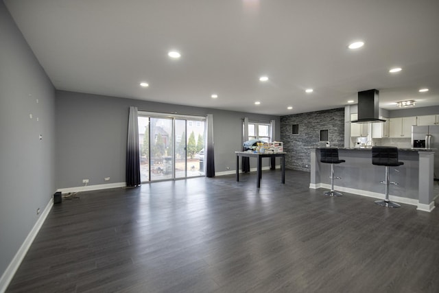 living area with dark wood-style floors, baseboards, and recessed lighting