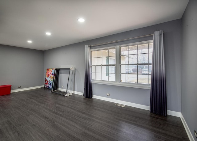 spare room with dark wood-style floors, recessed lighting, visible vents, and baseboards