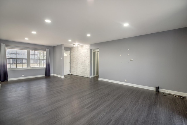 unfurnished living room with dark wood-style floors, recessed lighting, and baseboards