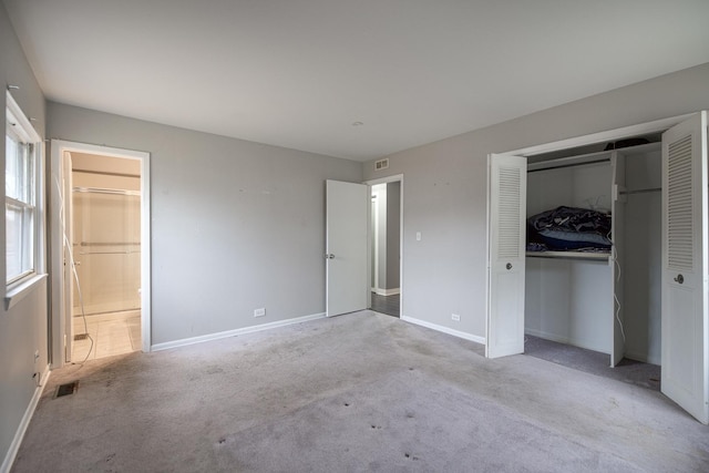 unfurnished bedroom featuring baseboards, carpet, visible vents, and a closet