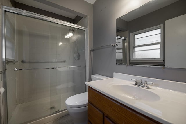 full bath featuring a stall shower, vanity, and toilet