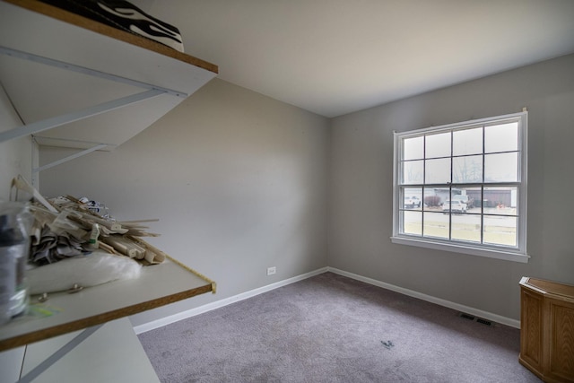 spare room featuring baseboards, visible vents, and carpet flooring