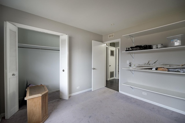 bedroom featuring a closet, carpet flooring, visible vents, and baseboards