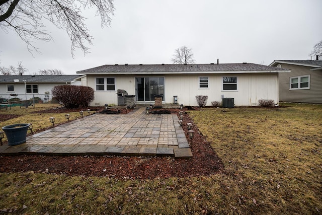 rear view of property featuring central AC, fence, a lawn, and a patio