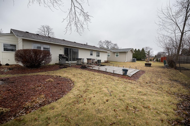 rear view of property featuring a lawn, a patio, and fence