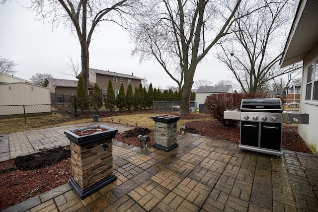 view of patio with an outdoor fire pit, a fenced backyard, and grilling area