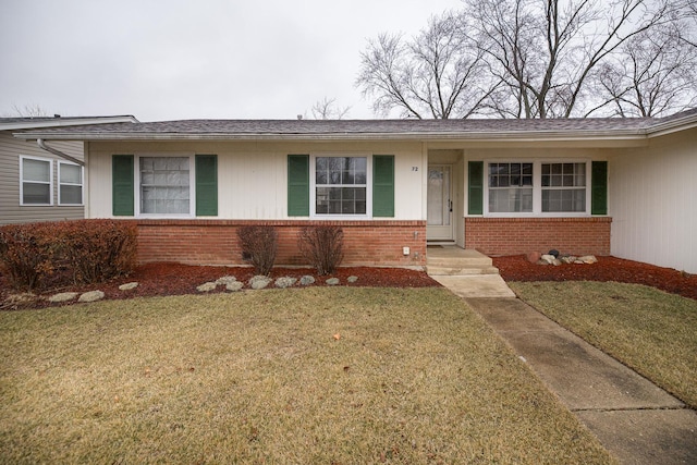 ranch-style home with brick siding and a front lawn