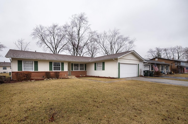 single story home with a garage, a front yard, brick siding, and driveway