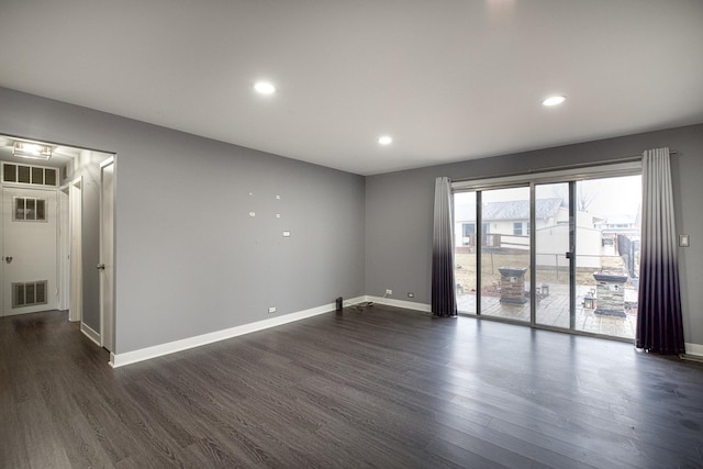 unfurnished room with recessed lighting, visible vents, dark wood finished floors, and baseboards