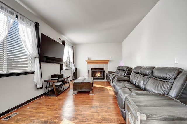 living room with hardwood / wood-style flooring and a tile fireplace