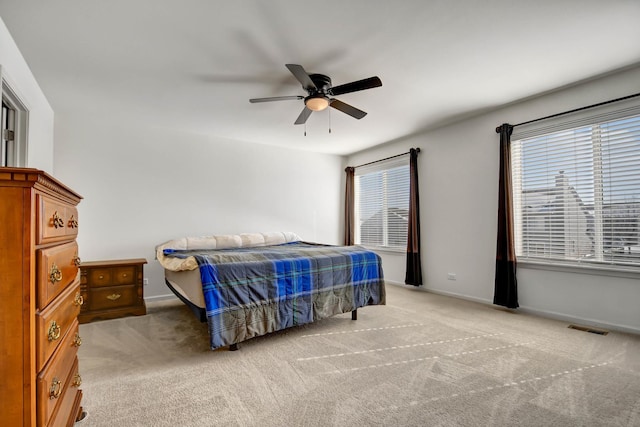 carpeted bedroom with ceiling fan and multiple windows