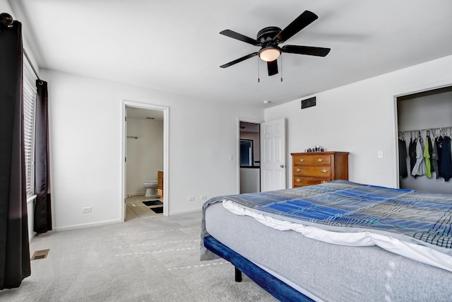 carpeted bedroom featuring ceiling fan, ensuite bathroom, and a closet