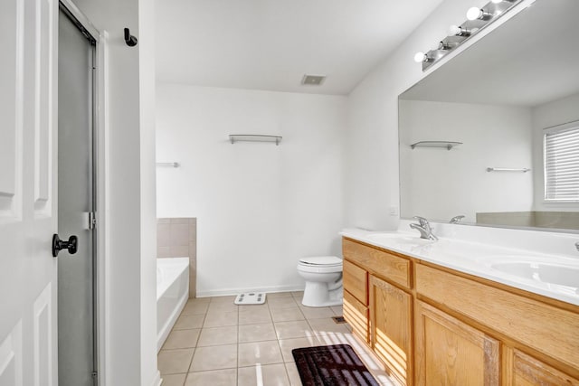 bathroom featuring tile patterned flooring, vanity, toilet, and a bathing tub