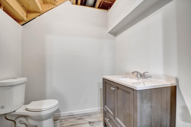 bathroom with vanity, wood-type flooring, and toilet